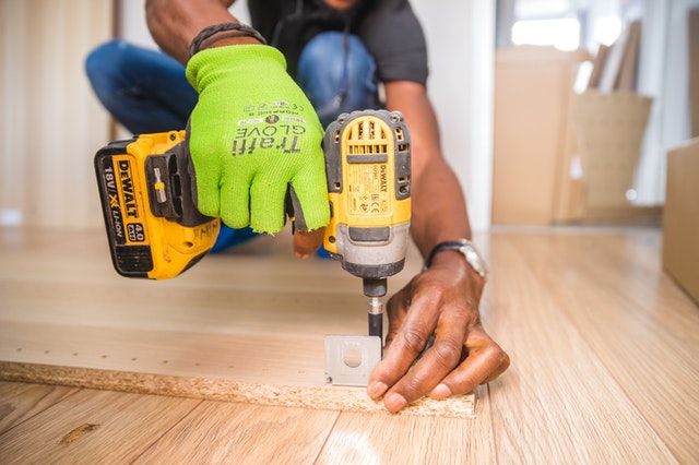 person using dewalt cordless impact driver on brown board 1249611